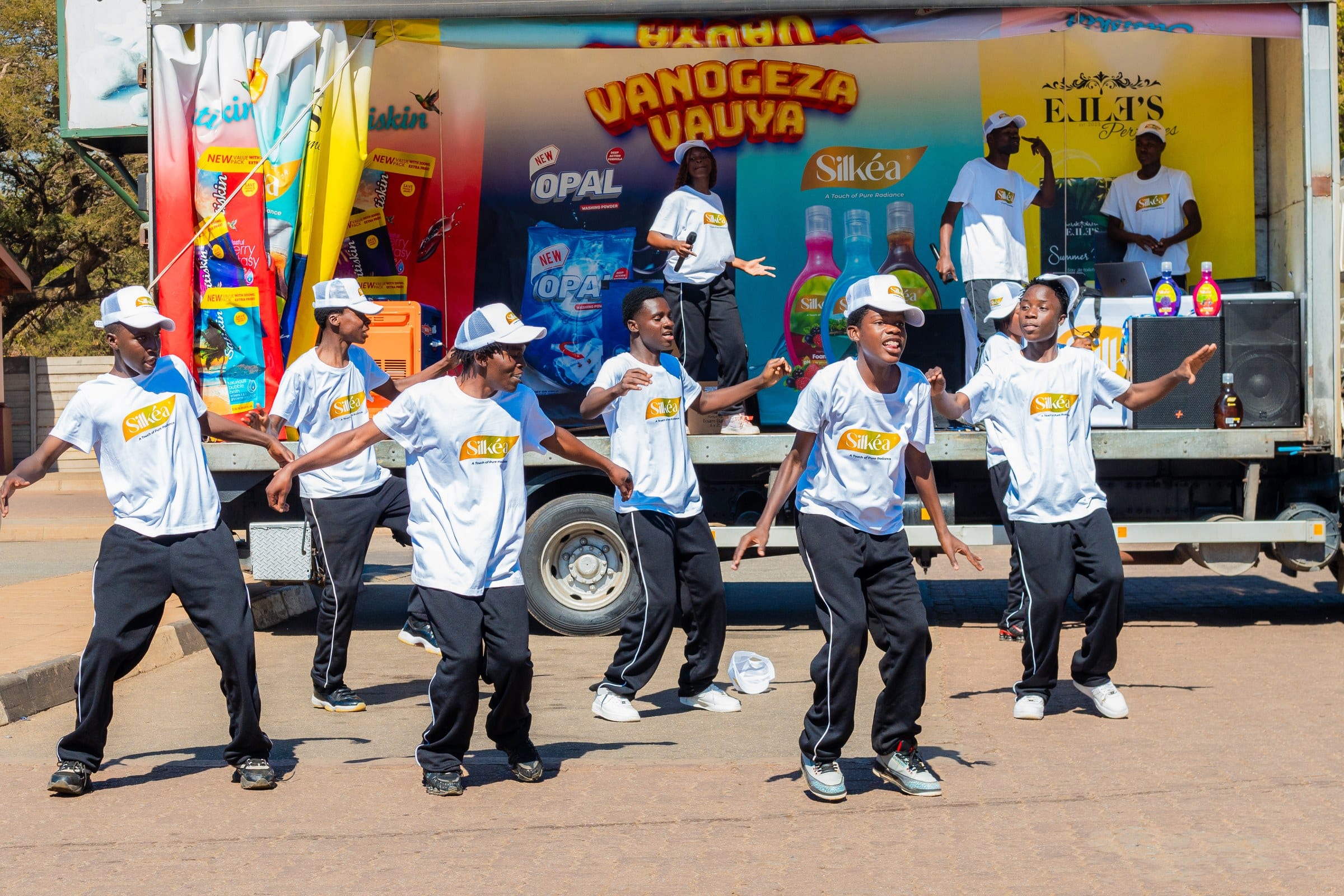 Dancers performing in front of a roadshow truck carrying the full brand range