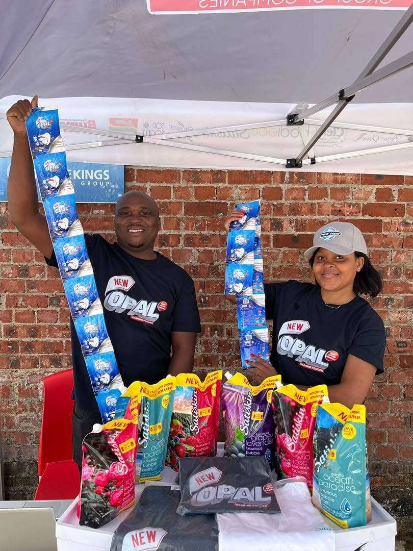 Promoters behind an Opal activation table stocked with the pack range